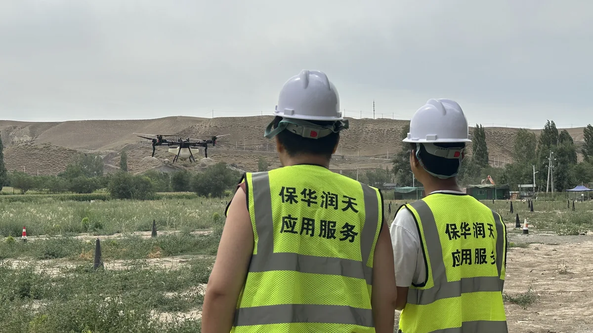 教员与学员观察植保无人机田间训练